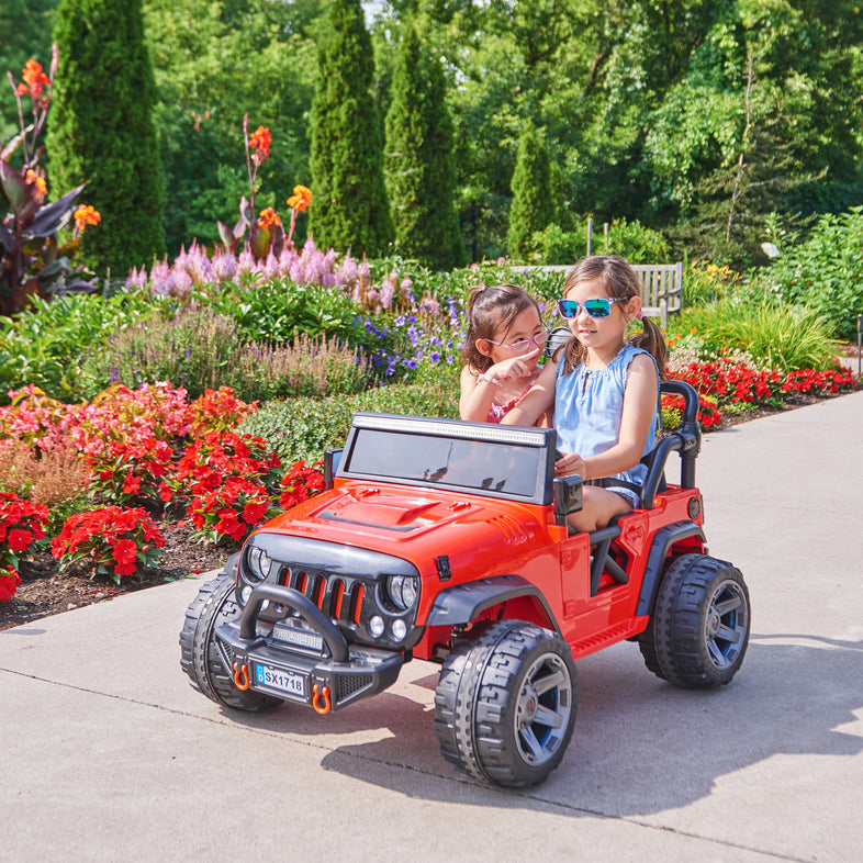 Kids on wheelz 12v jeep with 2 kids sitting in side it, red color , a lifestyle photo